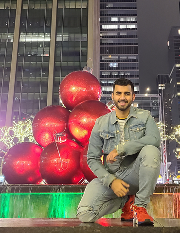 Student Muhammad D Arshad poses in front of holiday decor