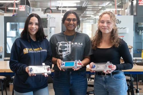 Three UC Davis Engineering students pose in the ESDC with their microscope projects