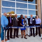 Seven people stand in front of the coffee center at a ribbon cutting ceremony